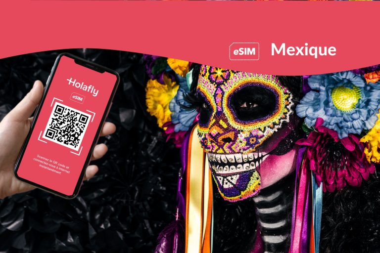 Une main tenant un téléphone à côté d'un crâne décoré pour la célébration du Dia de los muertos au Mexique