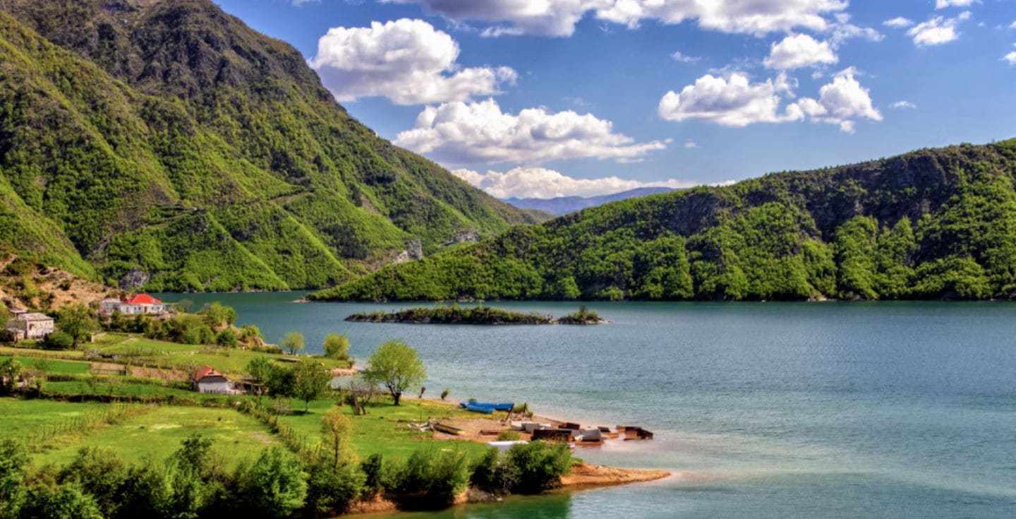 Un paysage avec des montagnes vertes et un lac en Albanie.