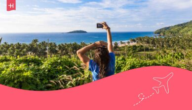 Femme voyageuse de dos prenant une photo d'une plage aux Philippines avec son smartphone connecté