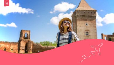 Voyageuse souriante en sac à dos devant la forteresse médiévale à Bac