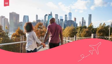 Couple se tenant la main en promenade à New York avec la Manhattan Skyline en arrière plan