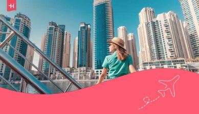 Jeune femme admirant les gratte-ciel du port de la Marina à Dubaï depuis un bateau de croisière