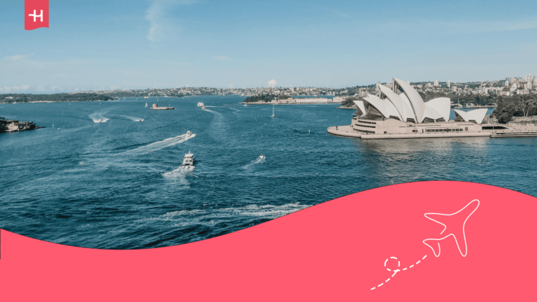 Vue aérienne de l'opéra de Sydney situé sur les rives du port de Sydney avec des bateaux naviguant dans la bay