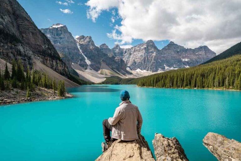 Randonneur profitant de la vue sur le lac Moraine pendant l'été dans le parc national Banff en Alberta au Canada
