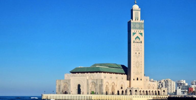 Une vue de la Grande Mosquée Hassan-II située à Casablanca, avec la mer et la ville en arrière plan.