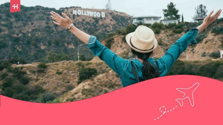Voyageuse les bras tendus face au Hollywood Sign aux USA