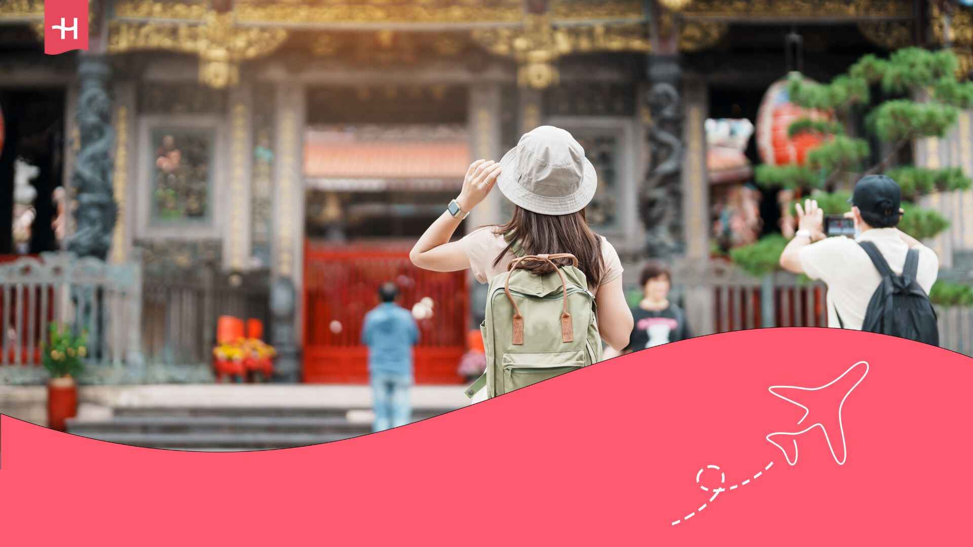 Une jeune femme vue de dos portant un chapeau en trainb de prendre une photo d'un temple en Chine