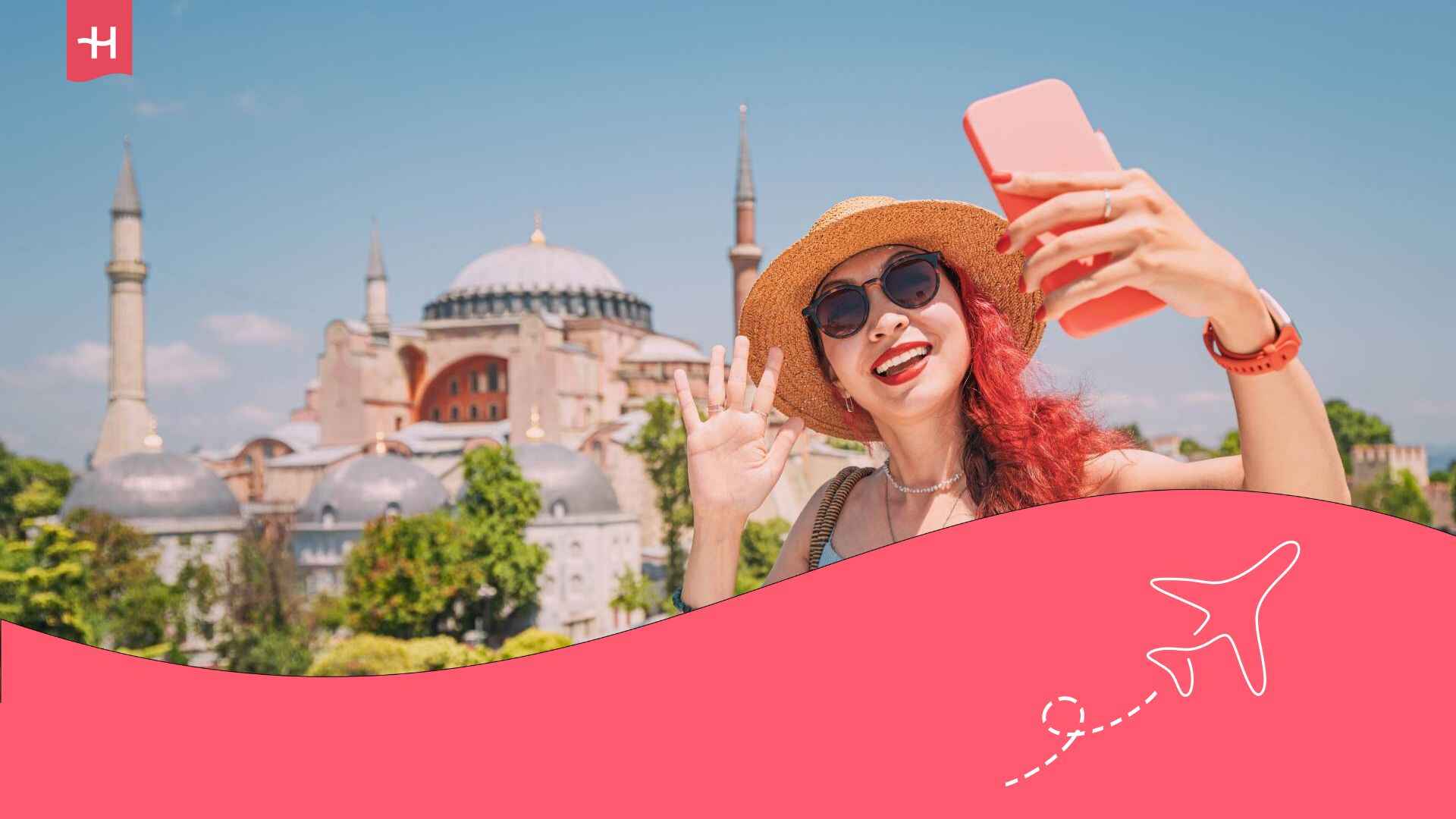 Une jeune femme avec un chapeau et des lunettes de soleil prenant un selfie devant Sainte Sophie à Istanbul