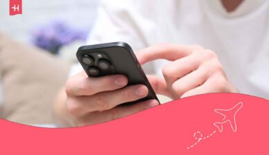 main d'un homme tenant un téléphone iPhone et carte SIM dévérouillée