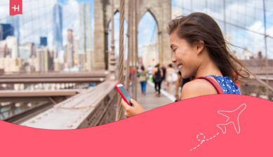 Jeune voyageuse sur le pont de Brooklyn regardant son téléphone connecté