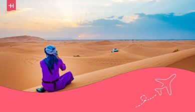 Voyageur de dos assis au sommet des dunes Erg Chebbi