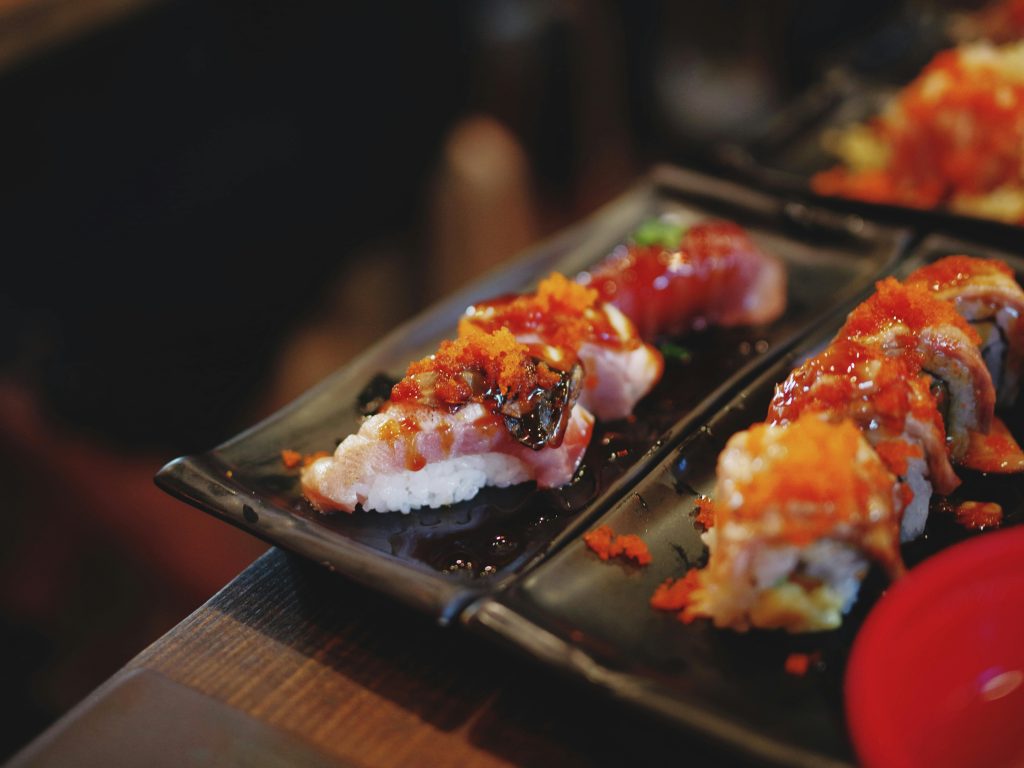 Deux plats avec des pièces de sushis japonais enrobés de sauce