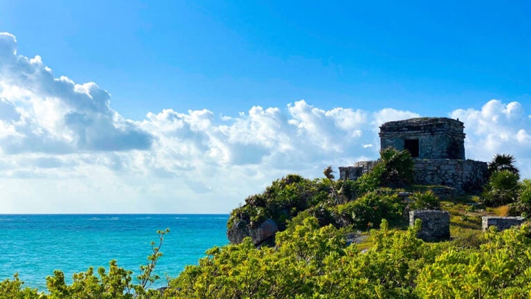 Vue de la mer à Tulum avec sur les hauteurs un vestige d'un ancien temple