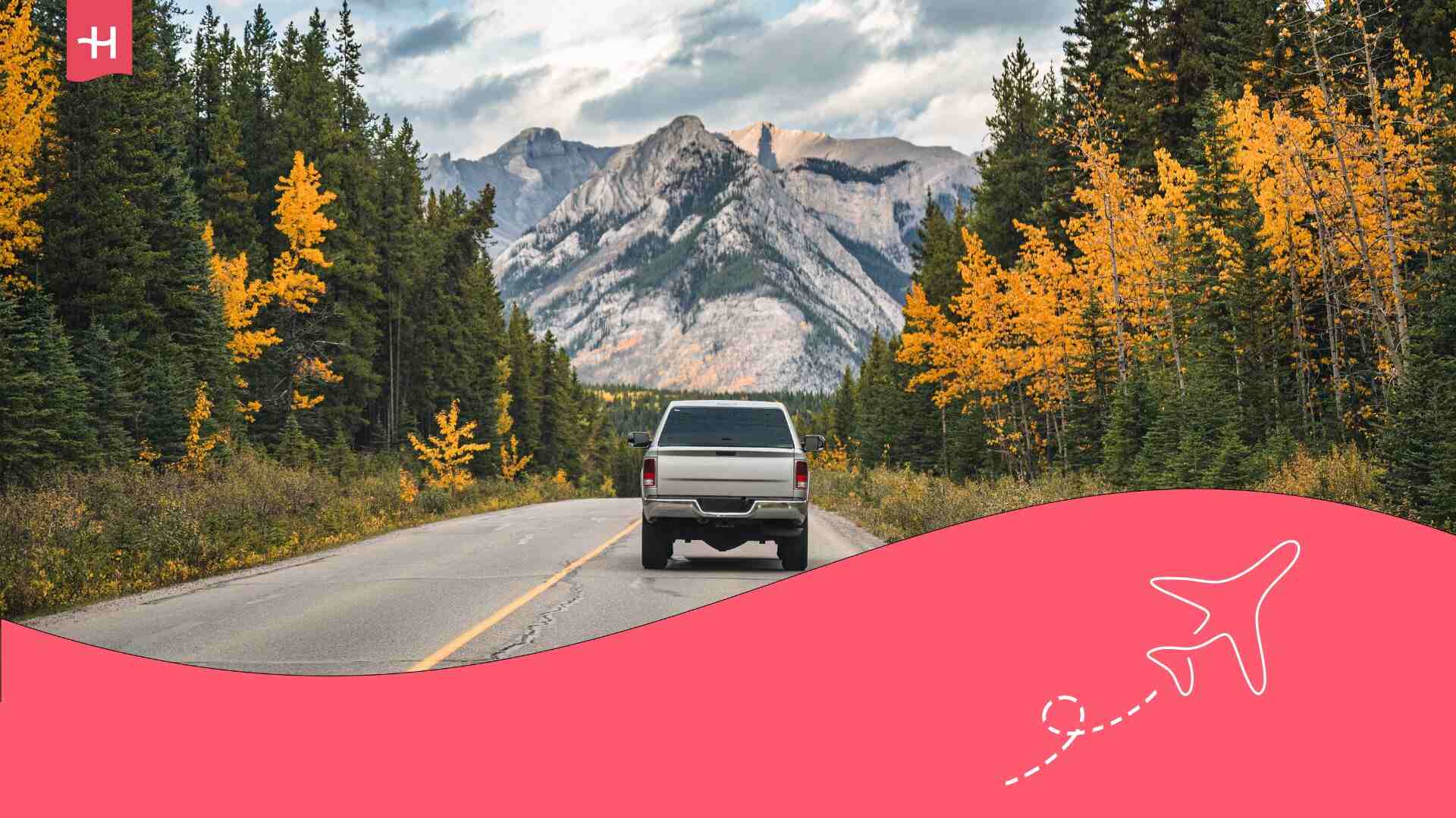 Vue arrière d'un pick-up conduisant sur route dans la forêt automnale et les montagnes rocheuses par beau temps au parc national Banff en Alberta au Canada