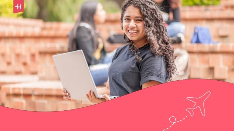 Jeune femme souriant avec son ordinateur portable en main