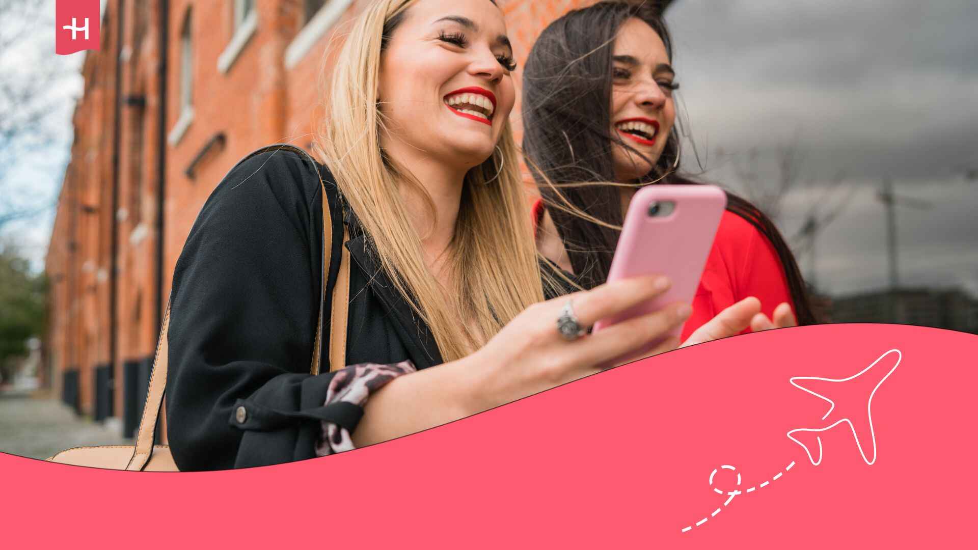 Deux jeunes voyageuses marchant dans la rue et l'une tenant son smartphone