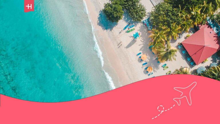 Vue arienne d'une plage avec un bâtiment au toit rouge sur une île des Caraïbes