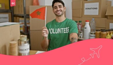 Garçon portant un t-shirt vert de bénévole et tenant un drapeau marocain à la main.