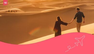 Couple se tenant la main et regardant le désert lors d'une excursion d'une journée au départ de Dubaï