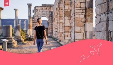 Jeune femme seule en voyage au Maroc, marchant de dos dans l'ancienne ville antique de Volubilis