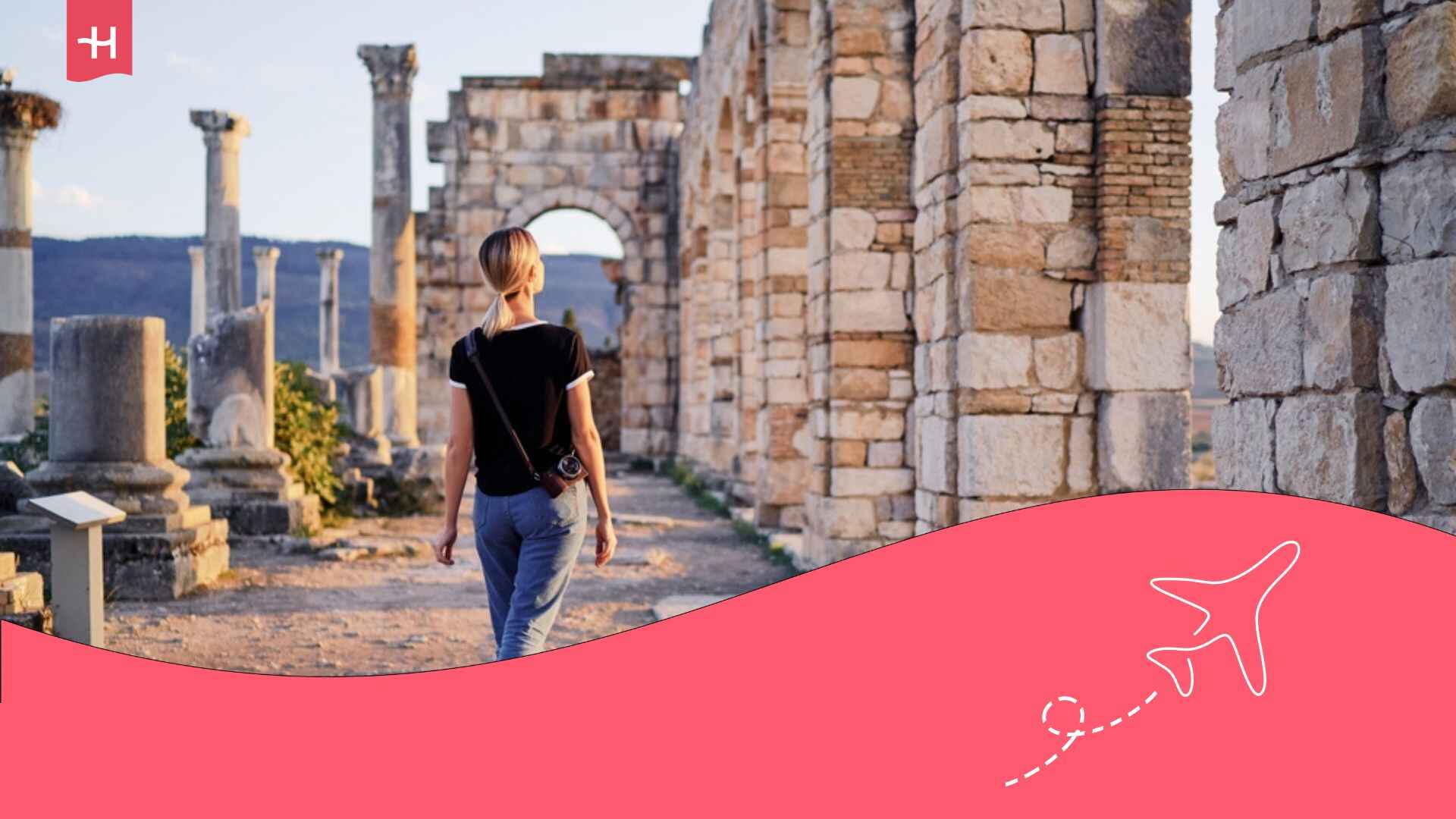 Jeune femme seule en voyage au Maroc, marchant de dos dans l'ancienne ville antique de Volubilis