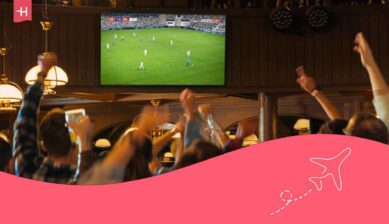 Supporteurs d'une équipe de football célébrant dans un bar en regardant le match à la TV