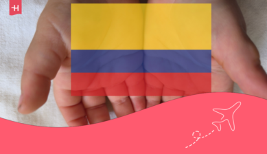 Volontariat en Colombie. Sur la photo, des mains tenant le drapeau colombien.