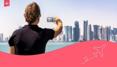 Homme de dos en voyage prenant une photo avec son GSM et utilisant le roaming de Base