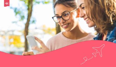 Deux jeunes femmes en voyage regardant leur GSM et connecté avec le roaming Mobile Vikings