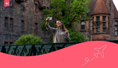 Une jeune voyageuse au utilisant son GSM en roaming avec Mobile Vikings au UK