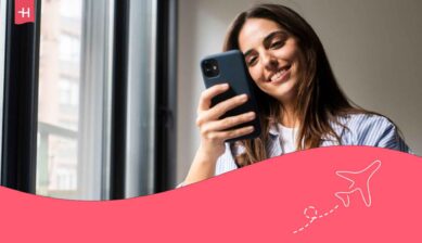 Femme souriante et regardant l'écran de son GMS utilisant une eSIM