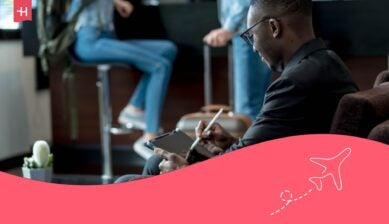 Un jeune homme à l'aéroport regardant sa tablette compatible SIM