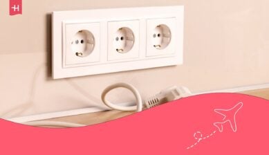 Câble de cordon d'alimentation débranché avec un groupe de prises électriques européennes blanches sur un mur beige