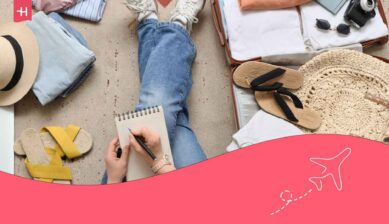 Jambes d'une femme assise au milieu de sa valise et affaire cochant sa list de vacances
