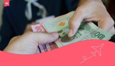 Main donnant des bahts thaïlandais en échange d'euros