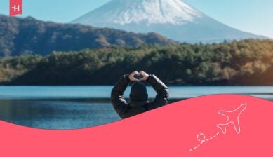 Femme de dos faisant face au Mont Fuji et représentant un coeur avec ses mains