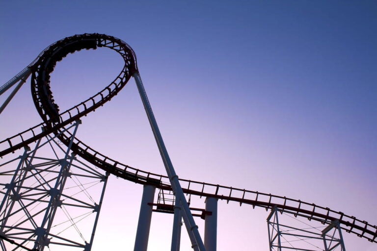 Impressionnante boucle de montagnes russes se découpant sur un ciel crépusculaire au parc Six Flags