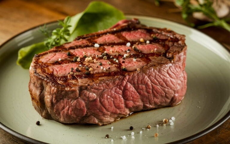 Épais faux-filet de bœuf de l'Alberta grillé et assaisonné, servi sur une assiette verte
