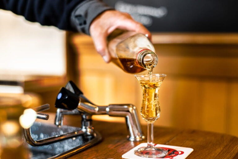 Main d'un barman servant du gin traditionnel hollandais, le Genevière