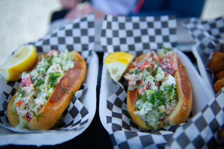 Deux guédilles au homard (lobster roll) généreusement garnies, servies avec un quartier de citron dans des barquettes.