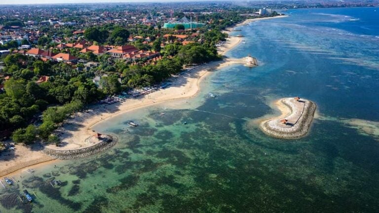Plage de sable clair bordée par des hôtels et resorts balnéaires dans la région de Sanur.