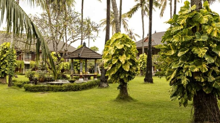 Jardin tropical avec un pavillon traditionnel au cœur d'un hôtel de style balinais à Legian.