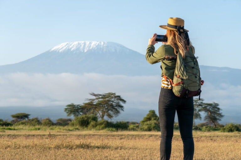 Une voyageuse photographie le sommet enneigé du mont Kilimandjaro depuis le Kenya.