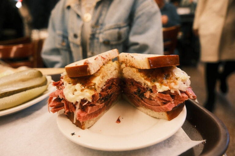 Épais sandwich au pastrami coupé en deux sur une assiette dans un delicatessen traditionnel.