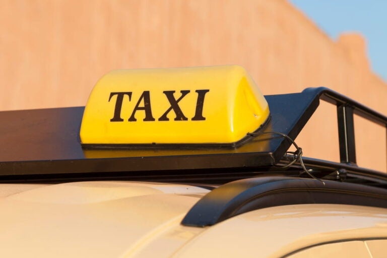 Gros plan sur le panneau d'un taxi beige à Marrakech