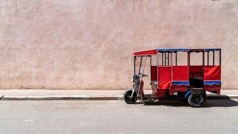 Tuk Tuk garé contre une façade dans une rue à Marrakech