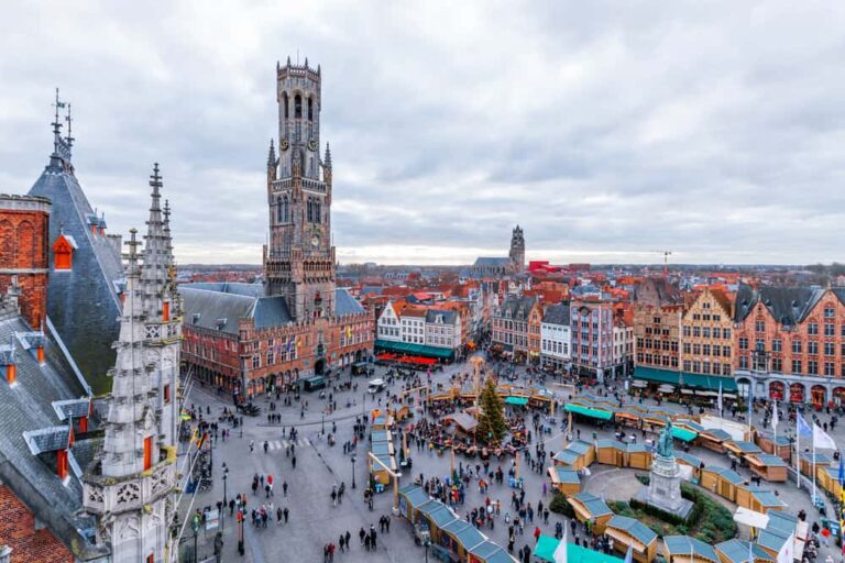 Vue aérienne sur la place et les chalets du marché de Noël de Bruges.