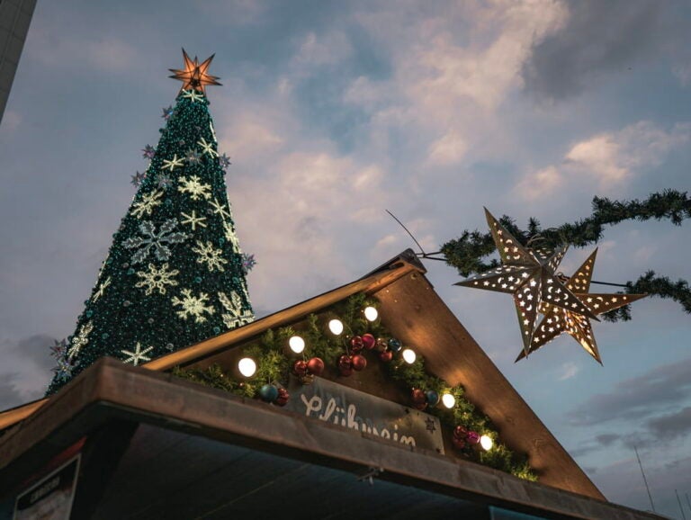 Toit d'un chalet en bois décoré et grand sapin illuminé au marché de Noël de Sapporo