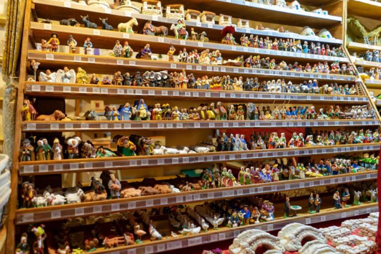 Étagères remplies de nombreux santons et décors de crèche sur un stand.