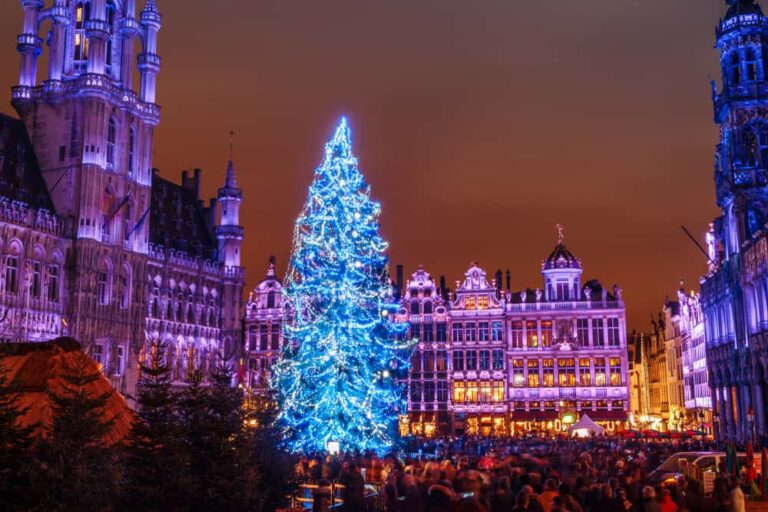 Majestueux sapin de Noël illuminé en bleu sur la Grand-Place de Bruxelles entourée de bâtiments historiques